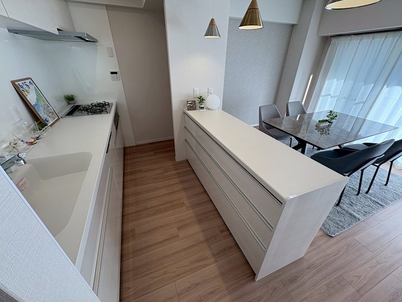 阪急逆瀬台アヴェルデ　1号館 白を基調とした清潔感あふれるキッチン。ワイドな作業スペースと豊富な収納で調理がスムーズに。家事動線も良く、毎日の料理が楽しくなる空間です。