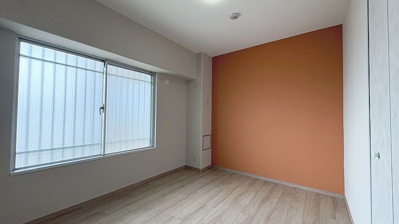 【CASA】カルチェ茨木 5.5帖の洋室。アクセントウォールのオレンジがフレッシュな印象。お子様のお部屋などにいかがでしょうか。
