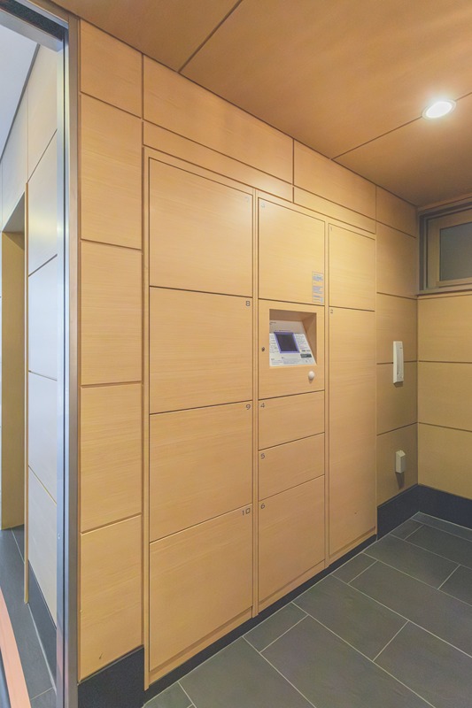 プレミスト京都烏丸通 外出中でも荷物が受け取れる宅配ボックス。ウッド調のデザインがエントランスを彩り、日々の暮らしをサポートします。