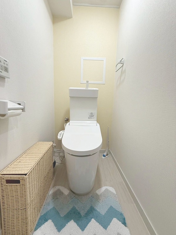 桂川ハイツ1号館 清潔感のあるトイレ空間。温水洗浄便座付きで快適にご利用いただけます。トイレットペーパーホルダーやタオル掛けも設置されており、日々の使いやすさに配慮しています。